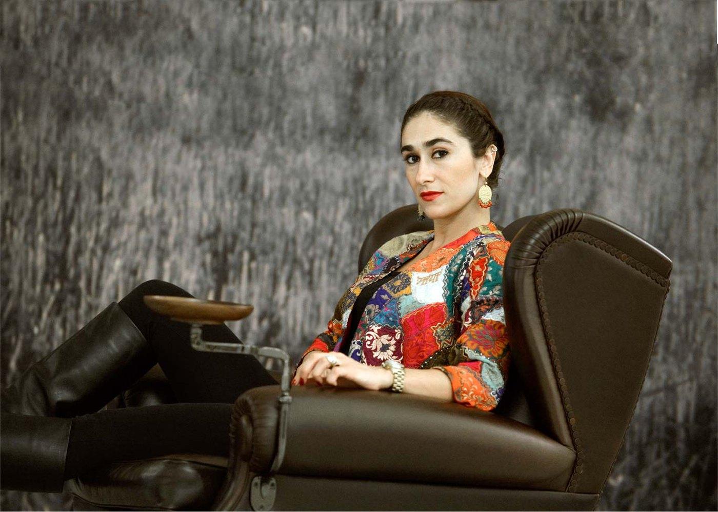 Maral Yazarloo seated in an embroidered jacket beside a motorcycle
