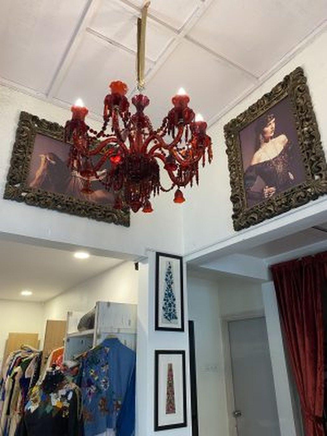 The studio, hung with framed artwork and garments