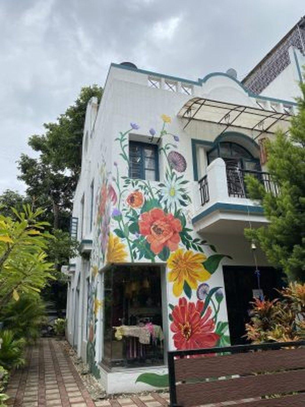 The House of Maral studio exterior, its facade painted with flowers